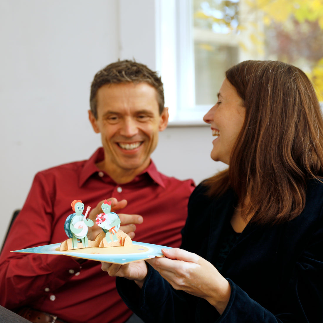 Two people looking & laughing at the Turtley In Love card