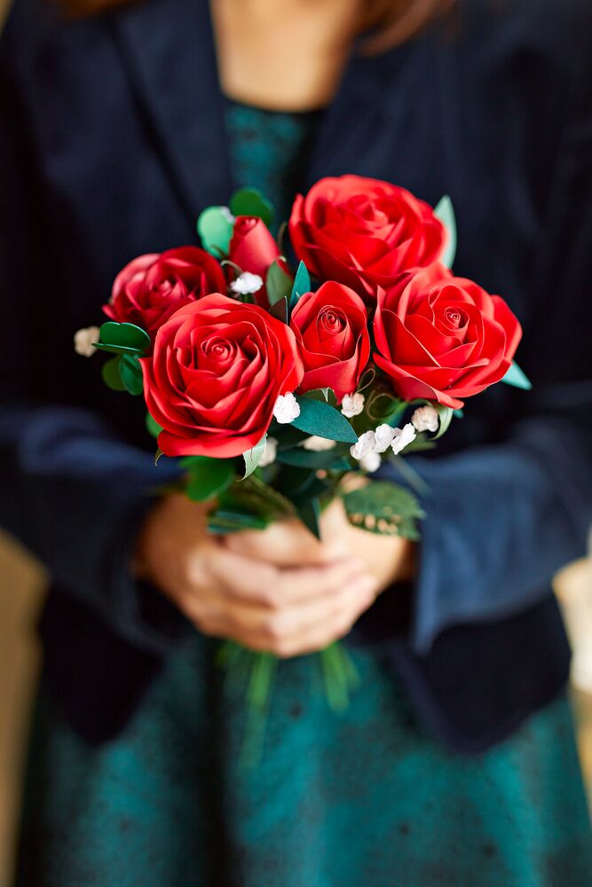 Woman receiving red handcrafted paper flowers